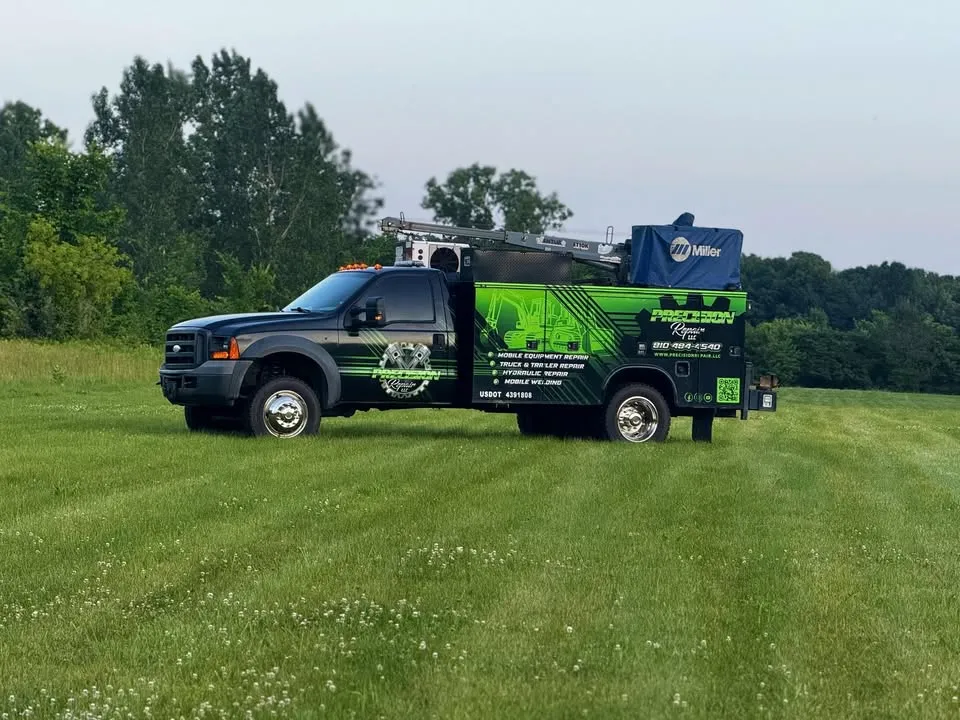 Precision Repair service truck parked in a field